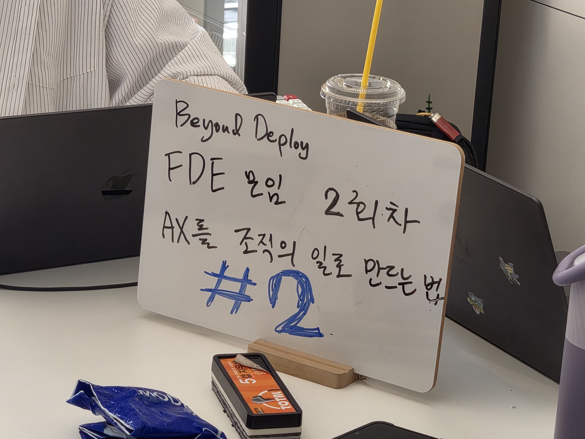 2회 케이스 토크 안내 보드 — "Beyond Deploy FDE 모임 2회차, AX를 조직의 일로 만드는 법"이라 적힌 화이트보드